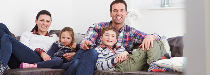 Família assistindo televisão na quarentena em casa